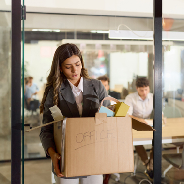 employee carrying box of possessions out of the office